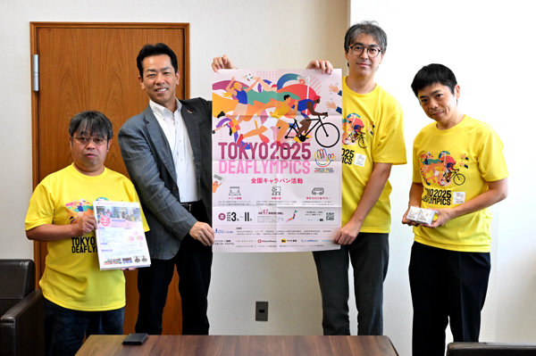 協会のみなさんと東京デフリンピックポスターを持って記念撮影をする宮崎市長の画像
